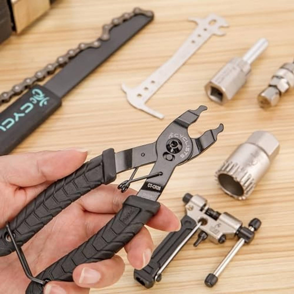 Chain tool pliers, adaptor bits, and puller parts on a tabletop