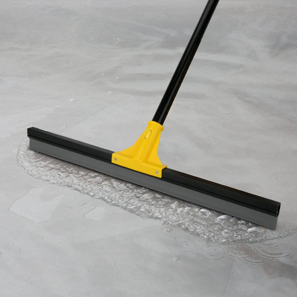 Yellow floor squeegee with black wiper blade on wet tile and concrete floor
