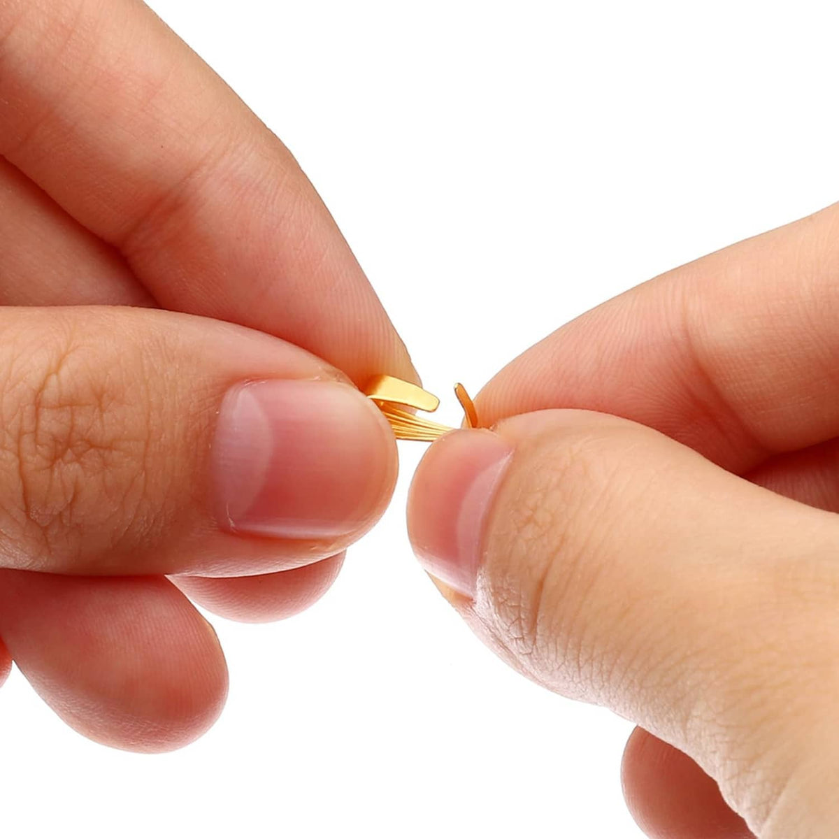 Close-up of hands pinching a gold tone snap bail hook charm