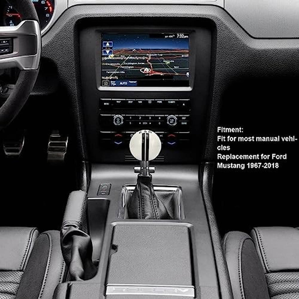Manual gear shifter knob with white top and chrome base on dashboard controls