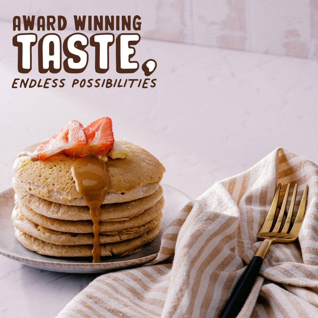 Stack of pancakes with peanut butter drizzle and peanut butter powder jar