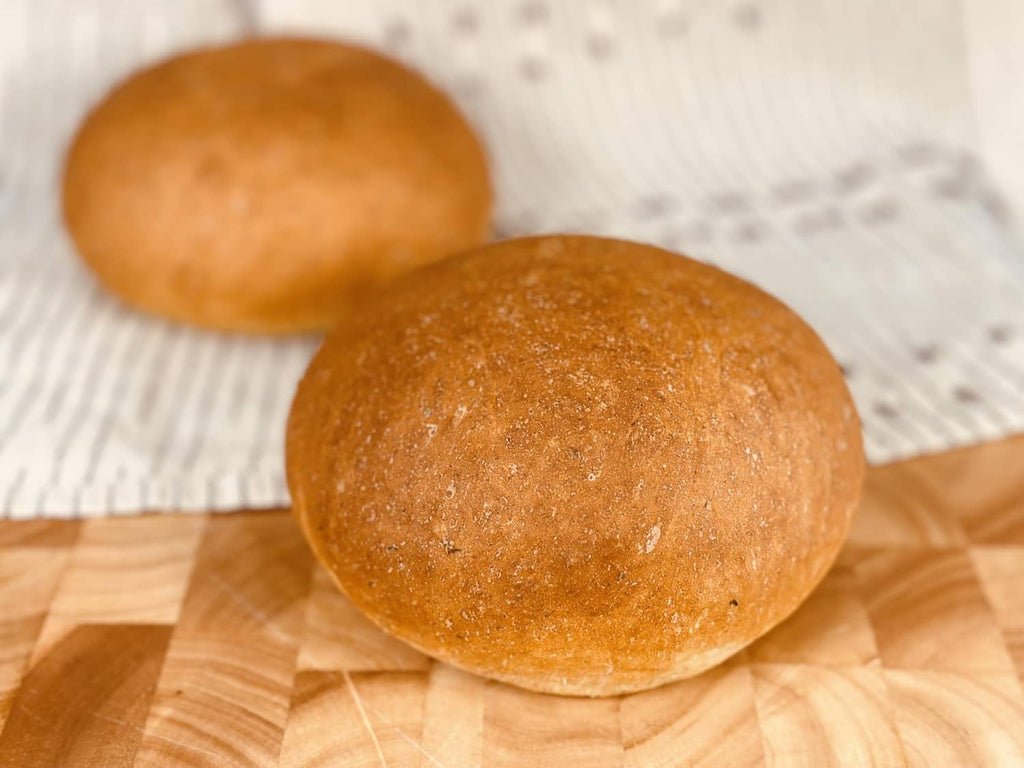 Golden potato bread rolls on a wood board