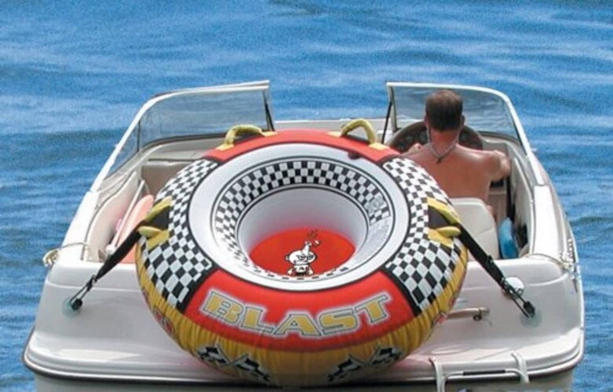 Inflatable tow tube with black securing straps and metal loops on boat
