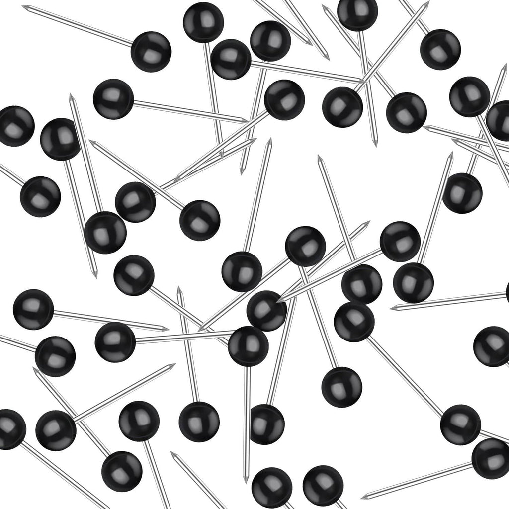 Scattered black push pins with round heads and silver metal needles.