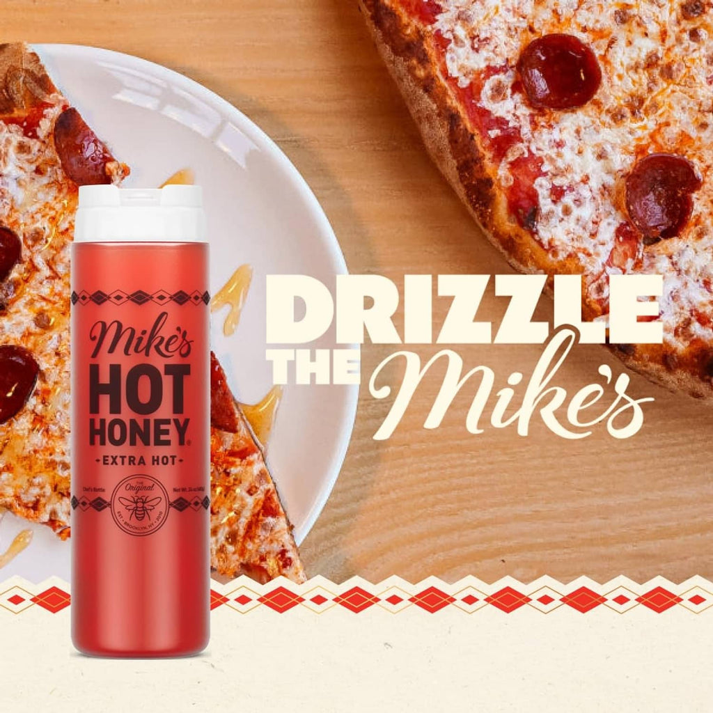 Extra hot honey squeeze bottle next to a pepperoni pizza slice