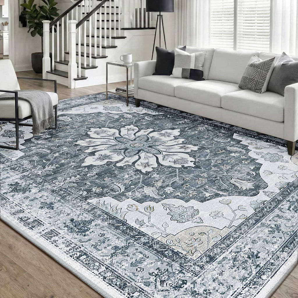 Blue-gray ornate rectangular area rug with distressed border and floral centerpiece