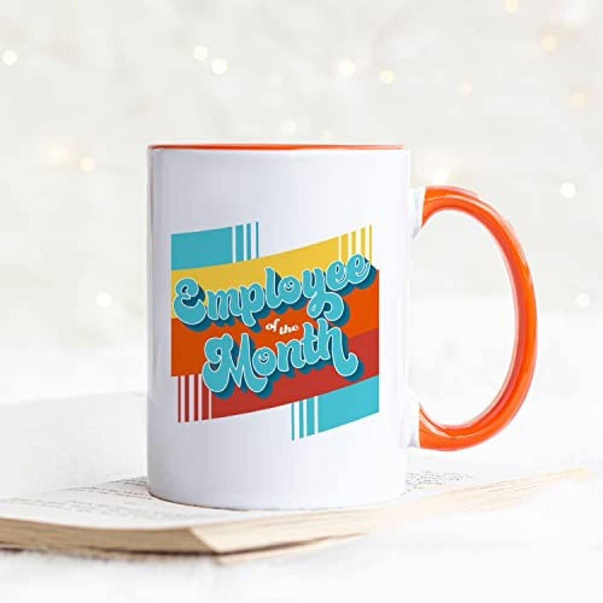 White ceramic mug with orange handle and 'Employee of the Month' graphic