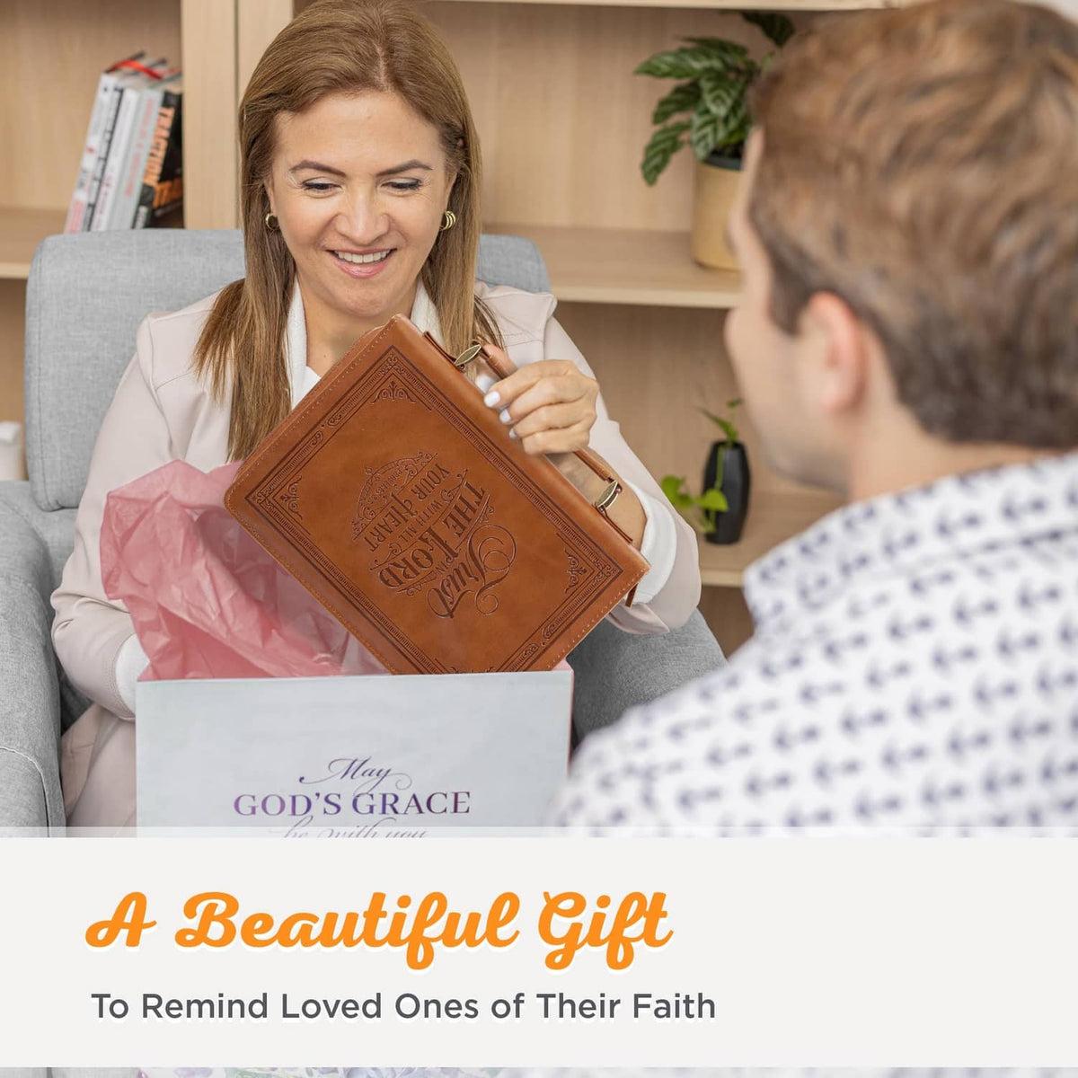 Brown vegan leather Bible cover held like a gift, featuring embossed front design