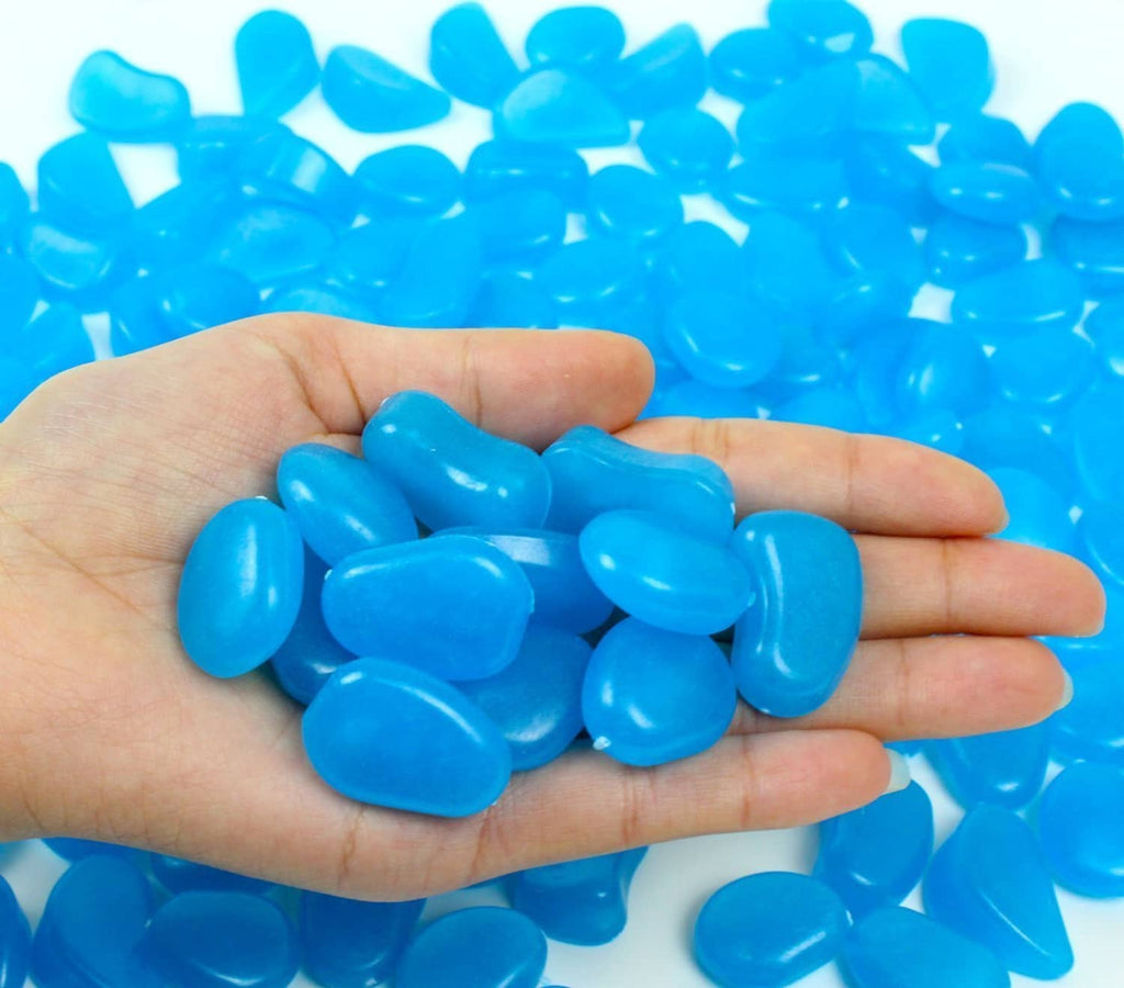 Blue glow in the dark pebbles, assorted smooth stones in an open hand.