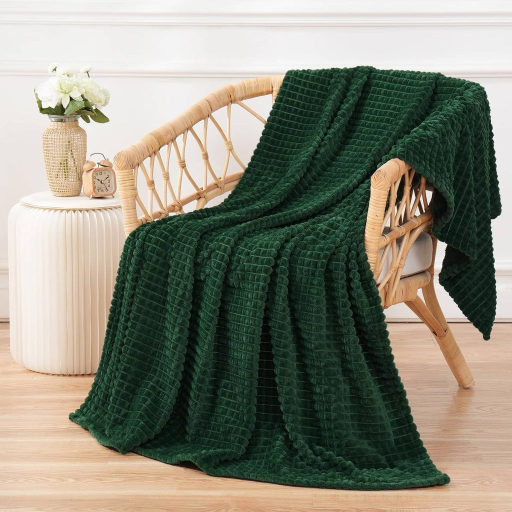 Dark green flannel fleece throw blanket draped over rattan chair, full throw coverage
