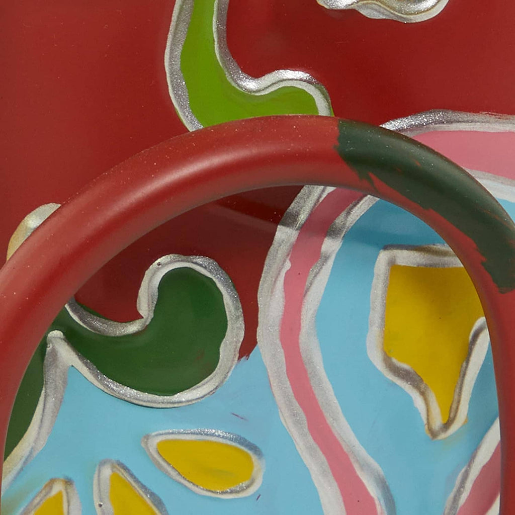 Close-up of painted metal dog sculpture: red, green, blue, and yellow decorative details