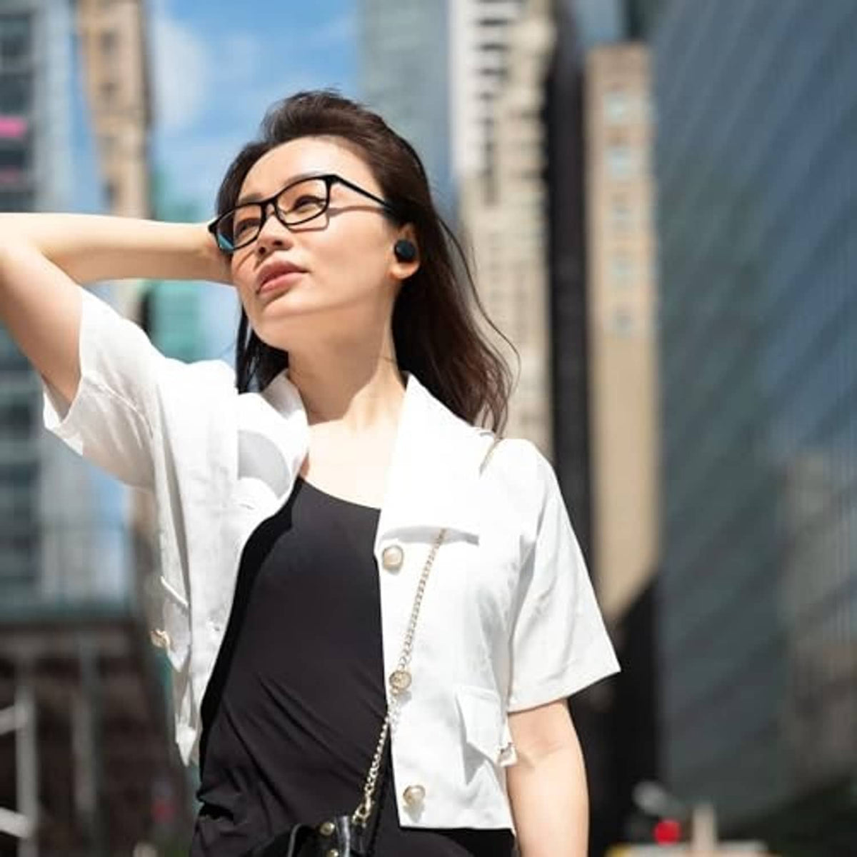 Woman wearing black JBL true wireless earbuds in her ears.
