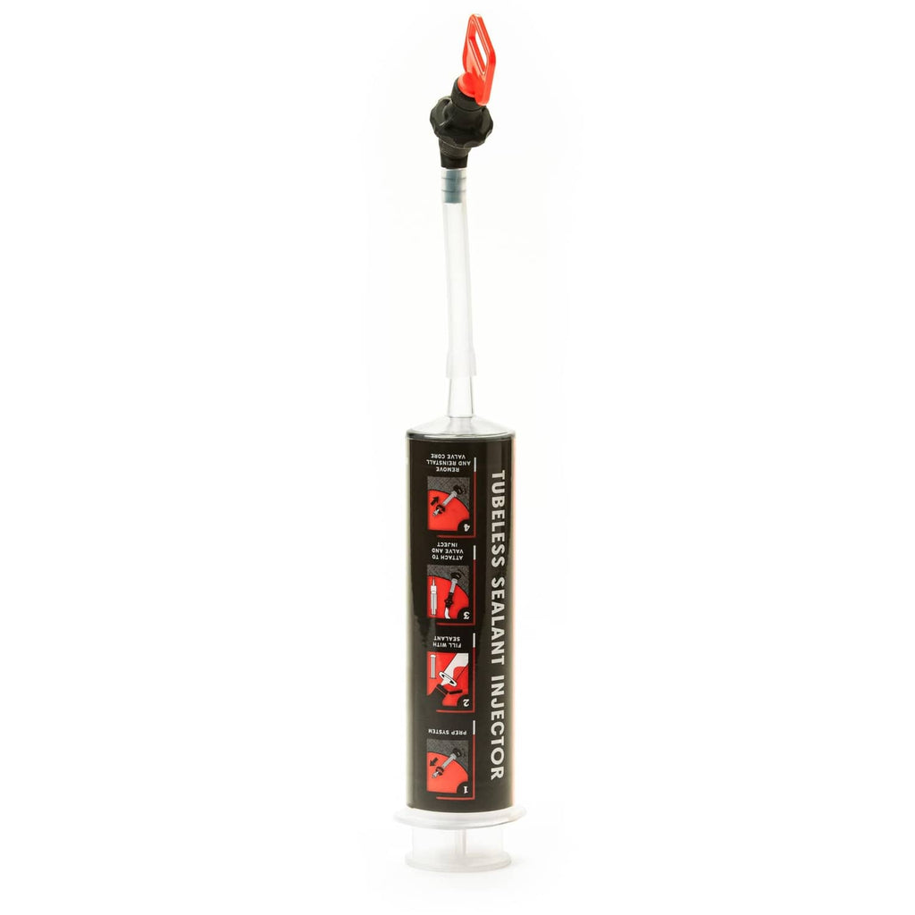 Tubeless sealant injector in a standing cylinder with red cap and clear nozzle