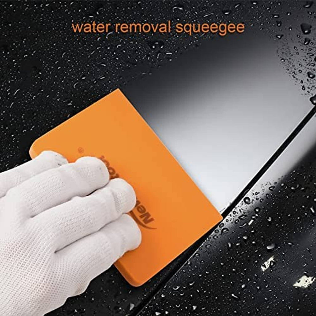 Orange silicone squeegee in use with gloved hand on wet window for water removal.