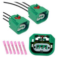 Two green headlight plug connectors with black wires and separate pink pin terminals