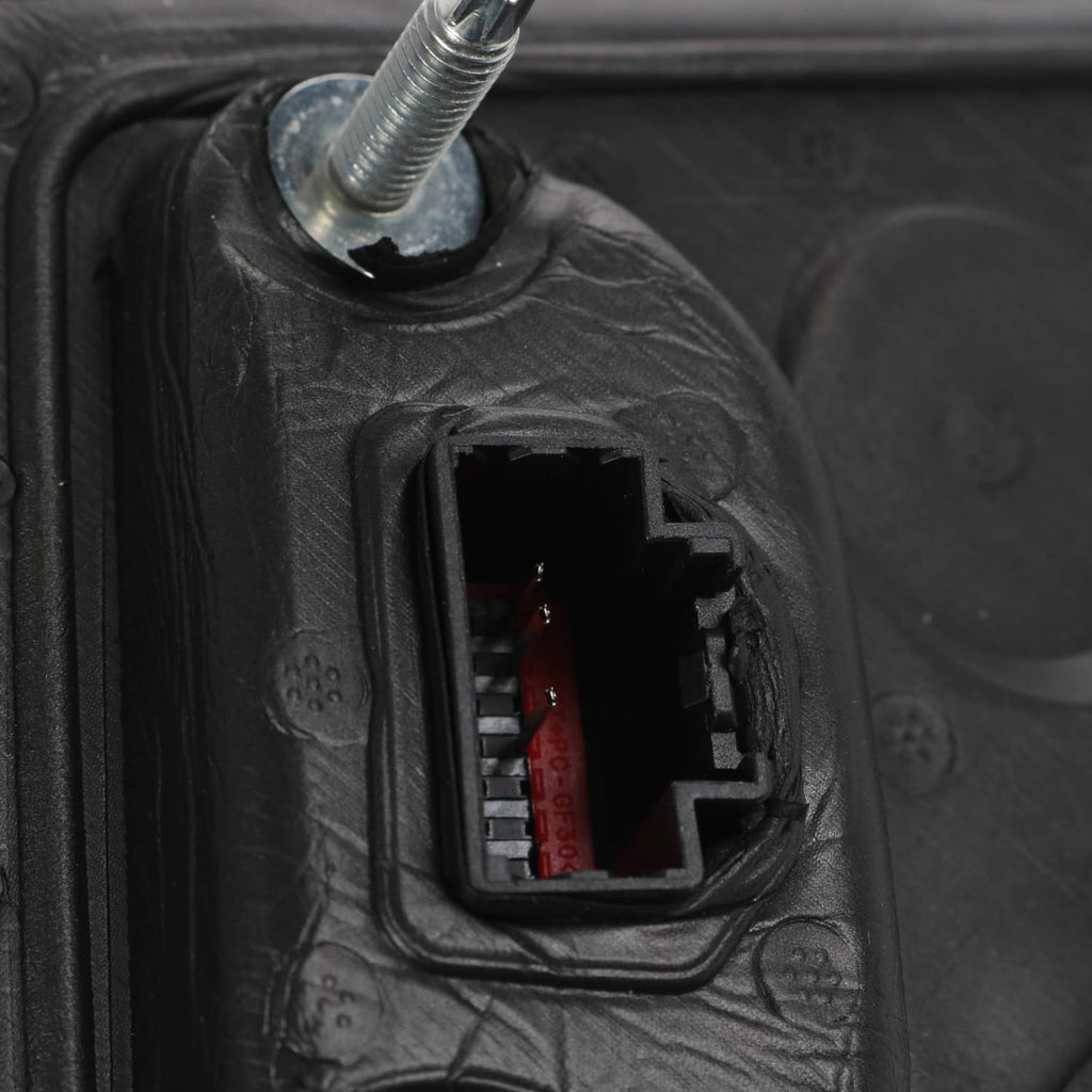 Close-up of black mirror wiring connector and mounting screw opening