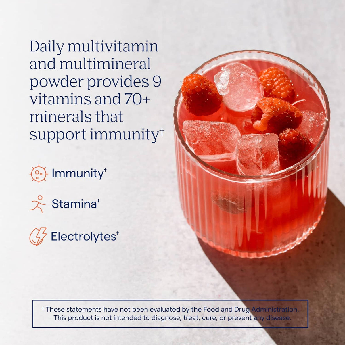 Raspberry electrolyte drink in a glass with ice and berry pieces