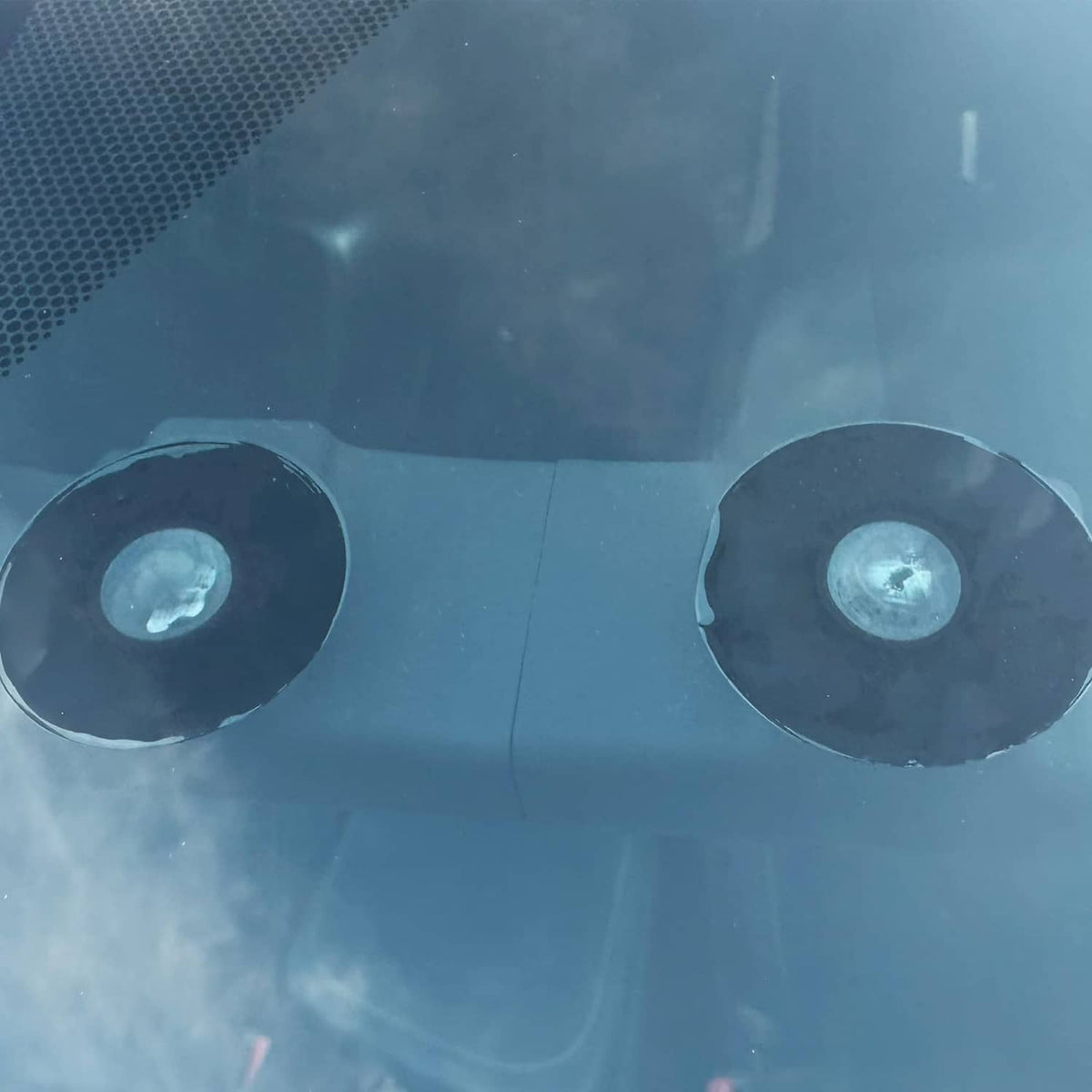 Close-up of two oval suction pads on a dark EZ Pass holder skin
