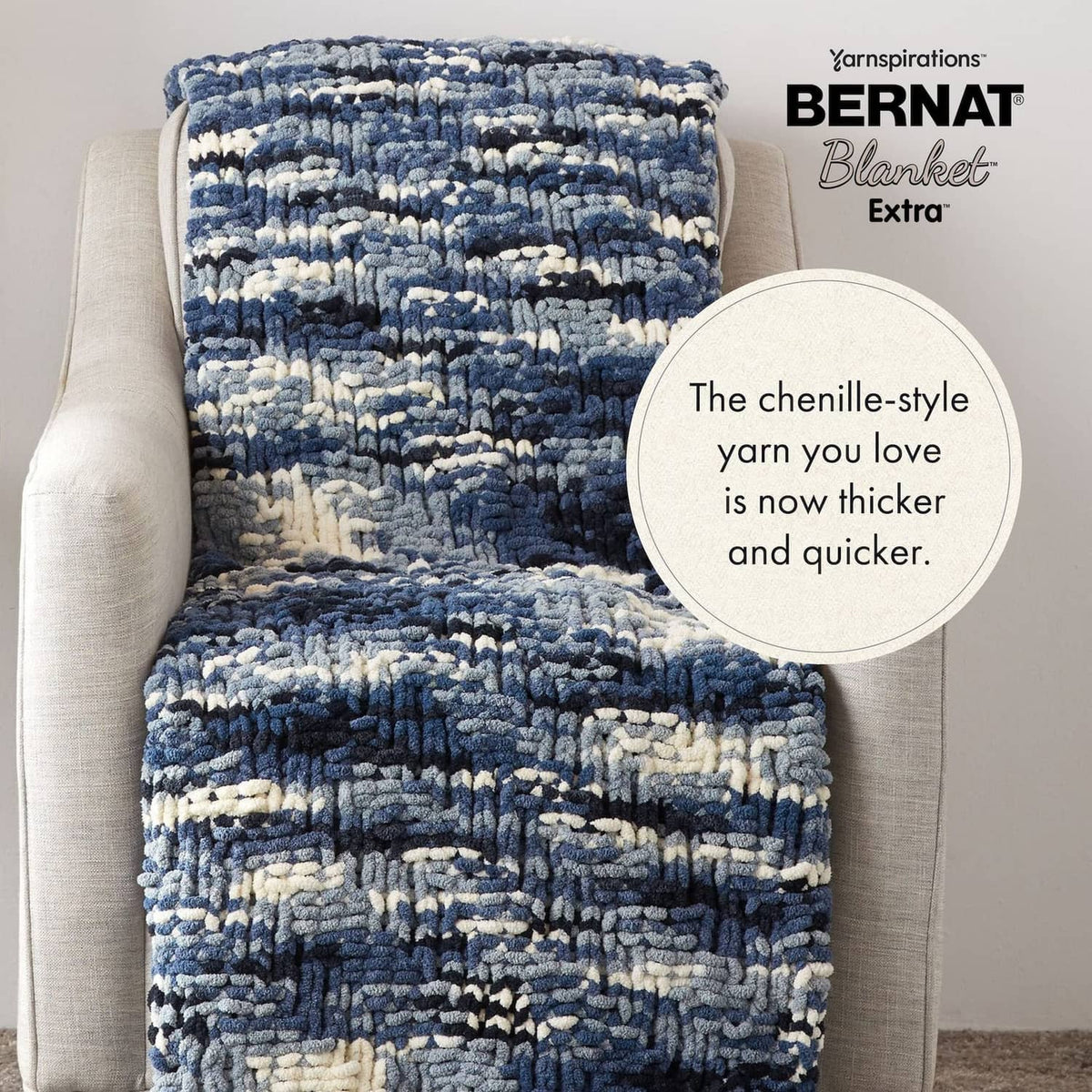 Chunky chenille blanket with blue and cream striped pattern on an armchair
