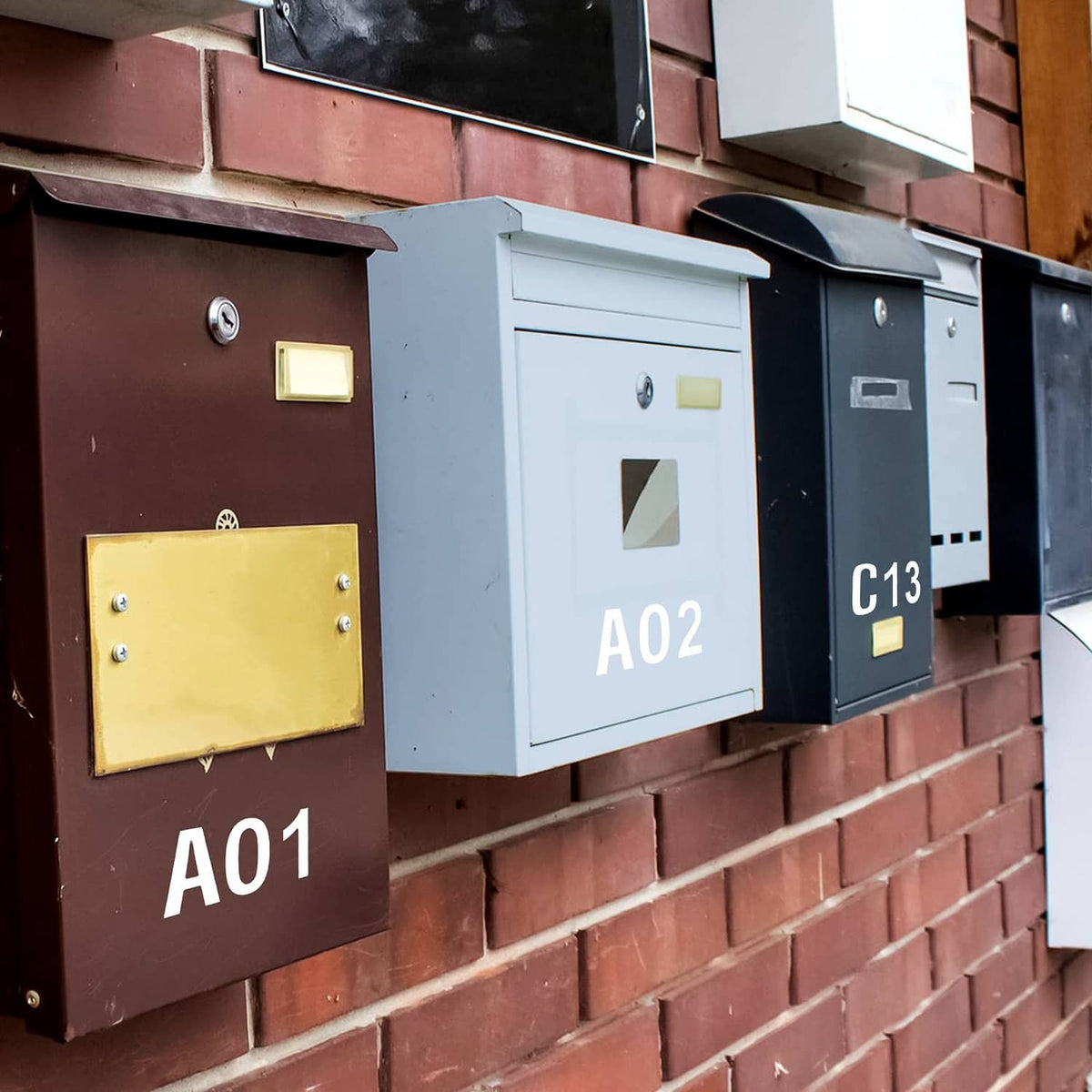 White vinyl mailbox letters and numbers on multiple mailboxes, labeled A01, A02, C13