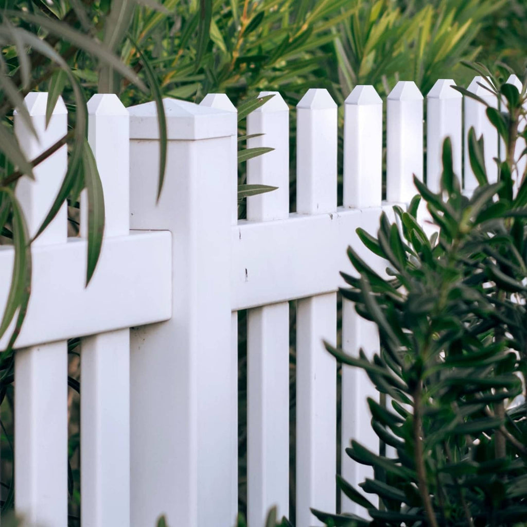 White vinyl dog-ear picket fence caps lined along the fence tops
