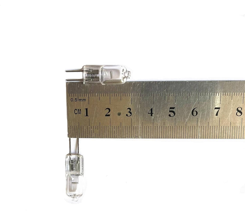 Clear G4 two-pin light bulb next to ruler, compact transparent glass envelope