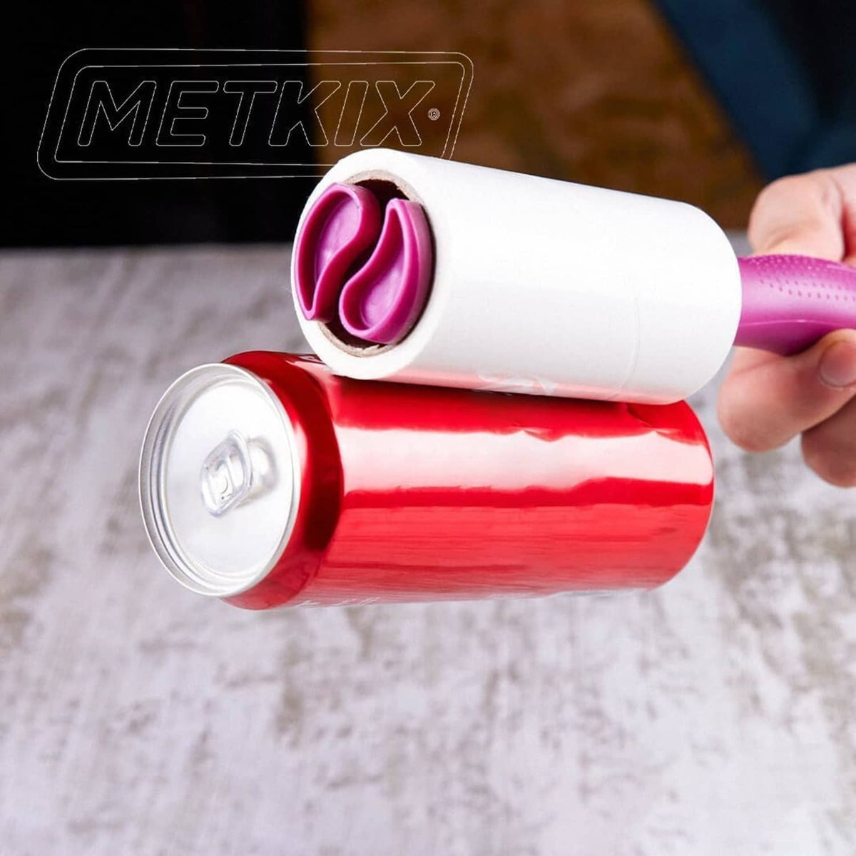 Close-up of pink and white Metkix lint roller refill rolls being held
