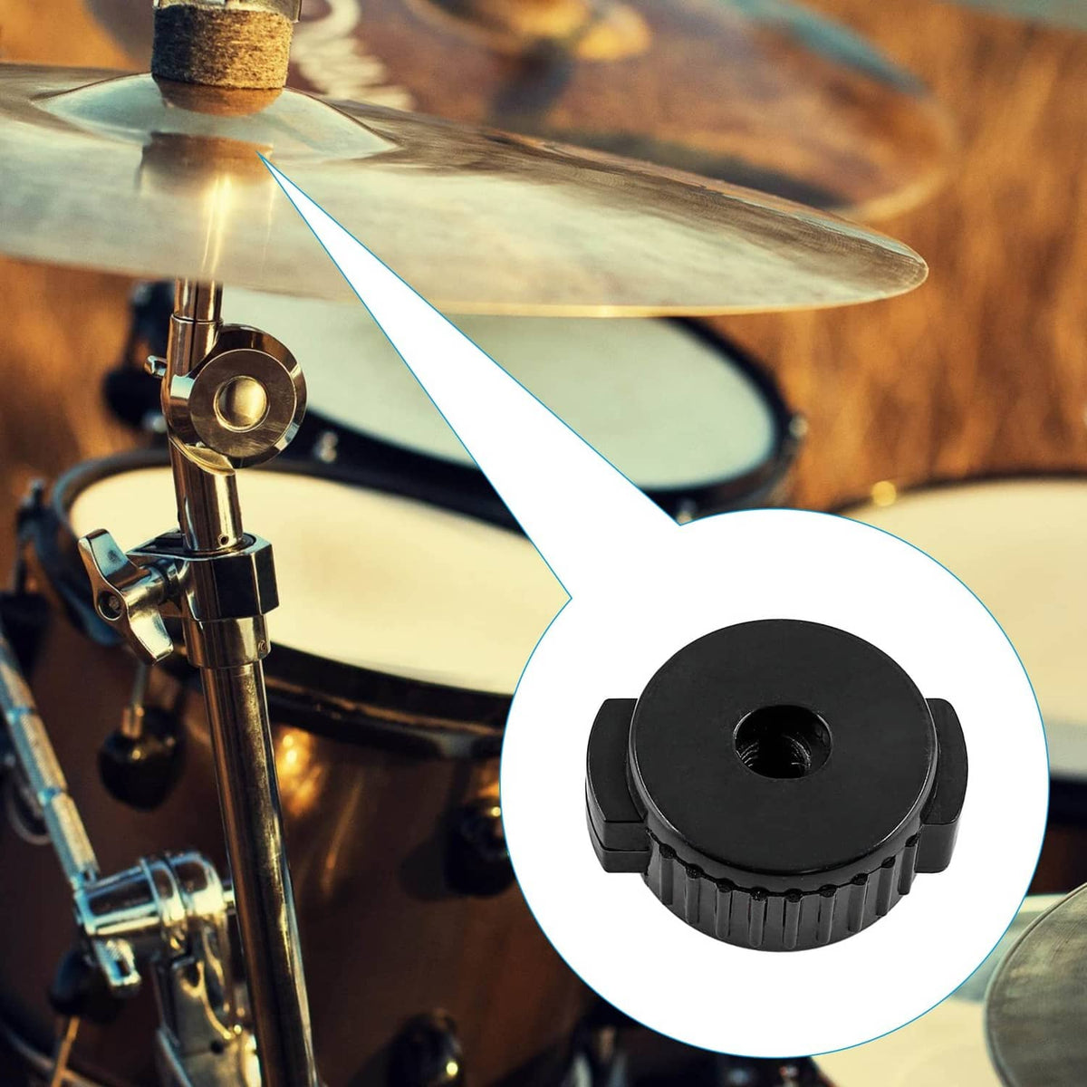 Black plastic cymbal nut near drum hardware, shown with center hole and ridged grip.