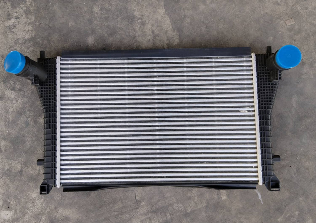 Turbo charge air intercooler with silver cooling fins and blue inlet/outlet caps
