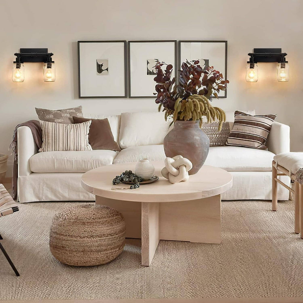 Black 2-light wall vanity light with two clear mason-jar shades glowing softly