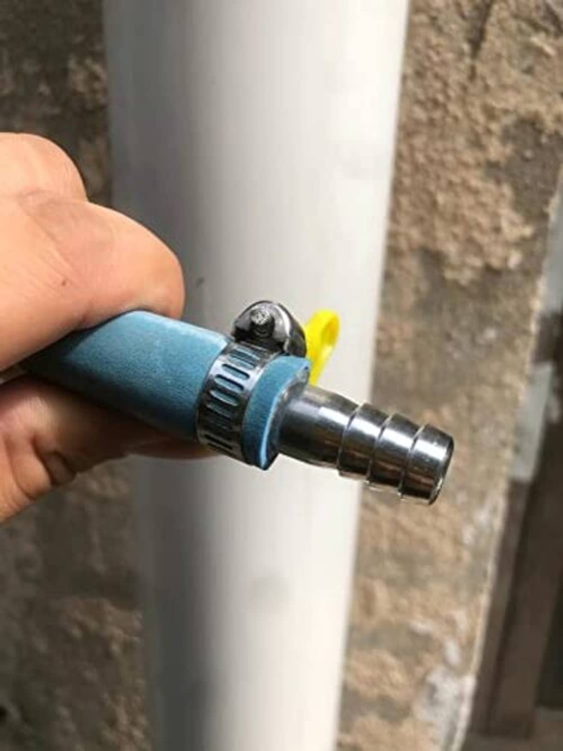 Stainless steel hose barb splicer installed with hose clamp on a pipe