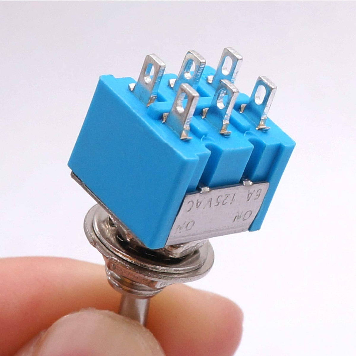 Mini DPDT toggle switch close-up, blue housing with 6-pin terminal pins