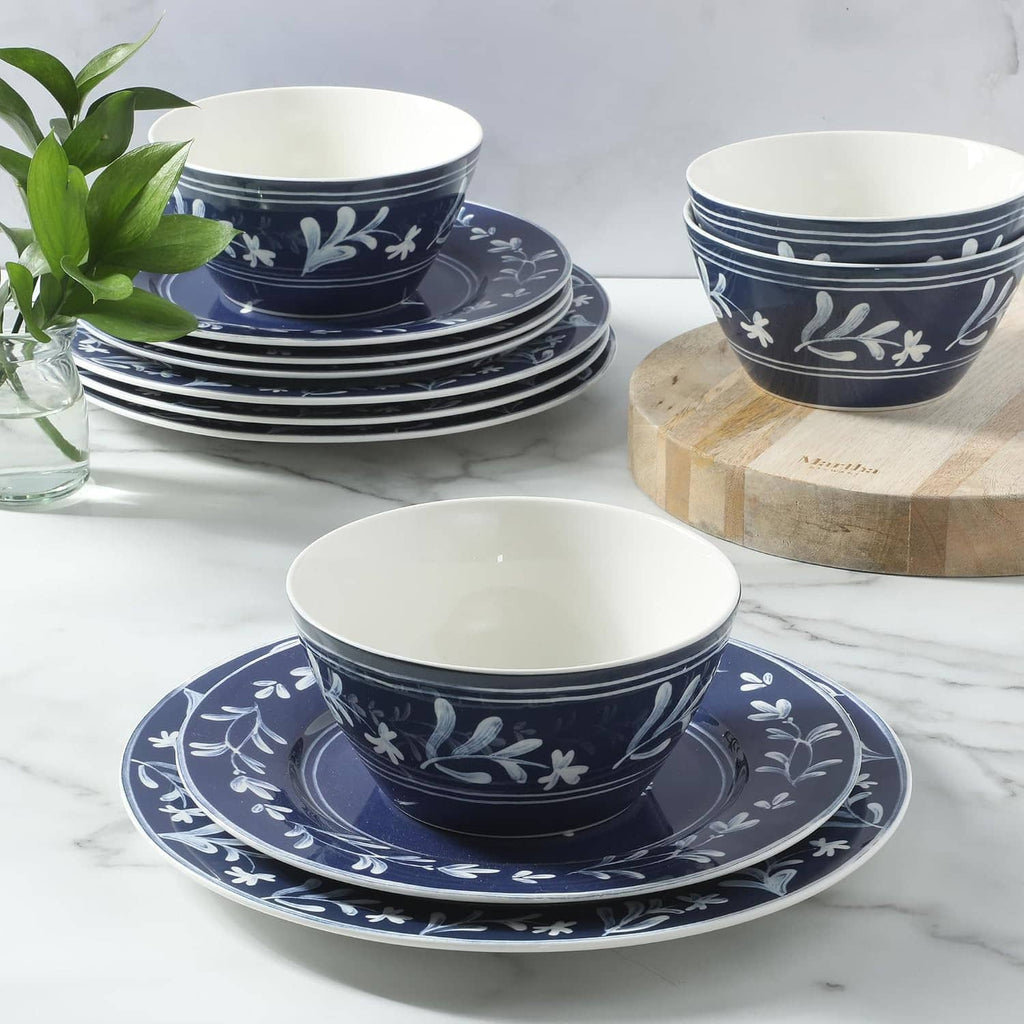 Dark blue dinnerware set with white floral trim: stacked plates and bowls for serving