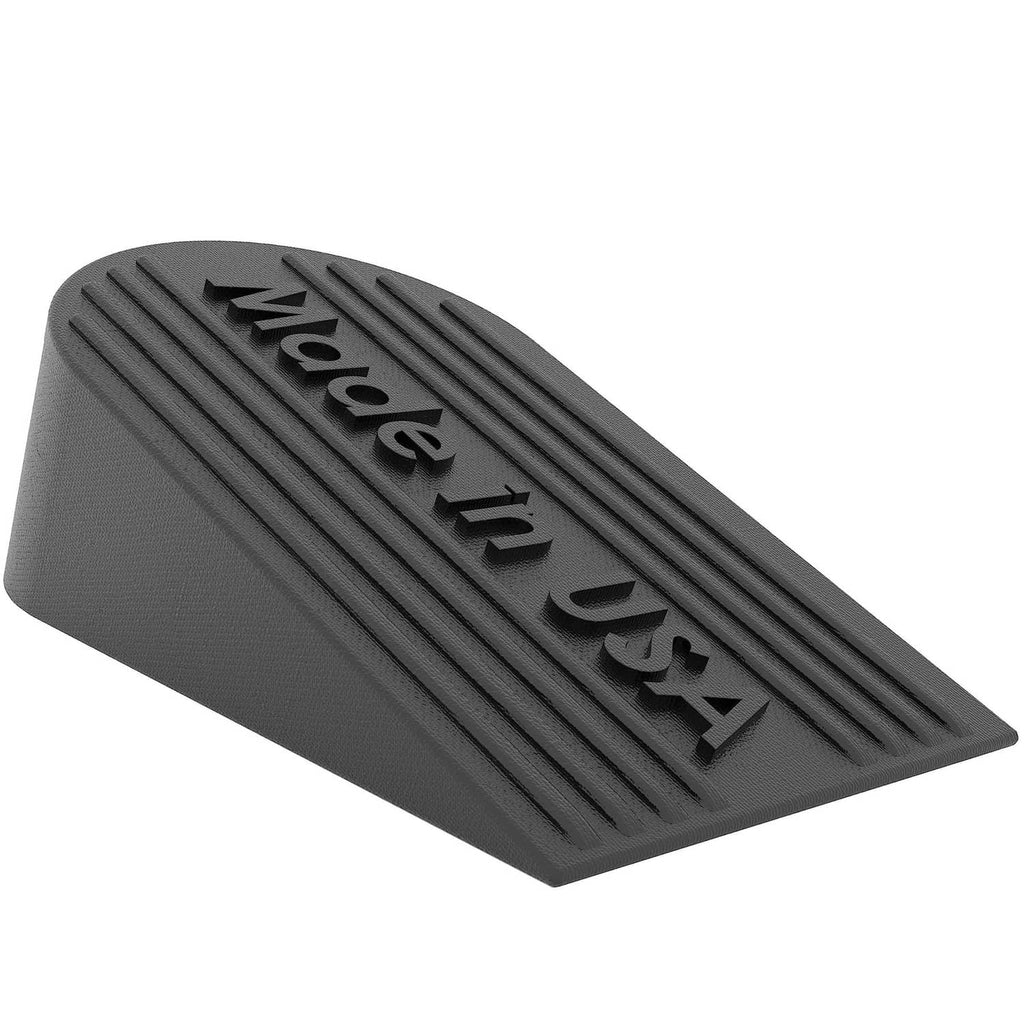 Black rubber door stopper angled view with embossed 'Made in USA' lettering