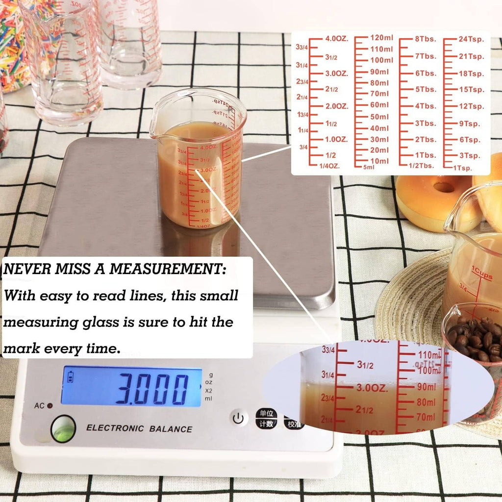 Clear small glass measuring cup with red volume scale markings and spout.