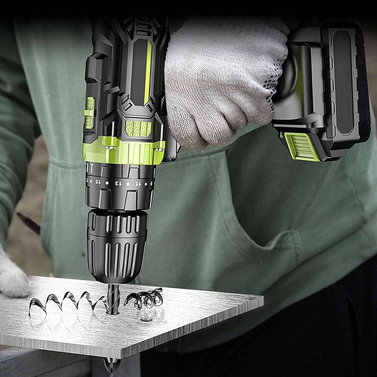 Masonry drill bit in use on metal sheet with gloved hand and drill body
