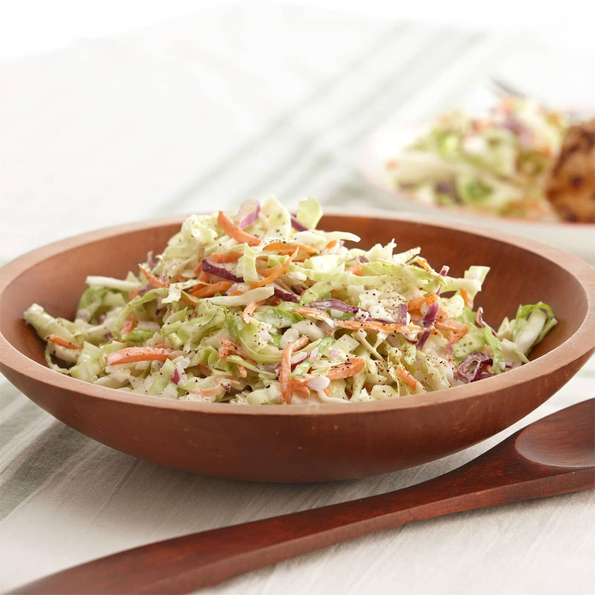 Bowl of shredded salad with lettuce, tomato pieces, and grated topping