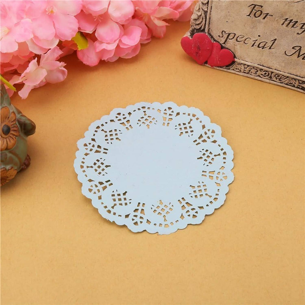 Round light blue paper lace doily, centered openwork motif and decorative border