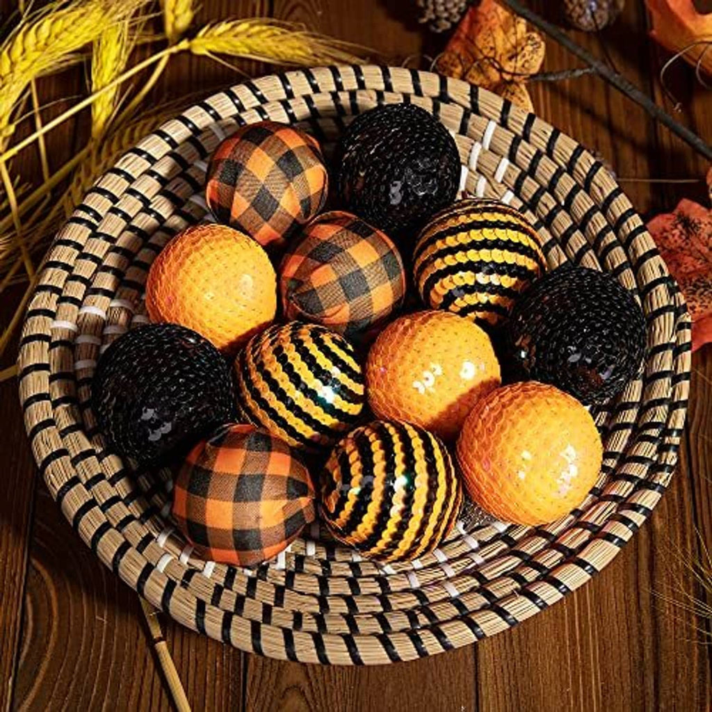 Black, orange, and gold sequin hanging balls with plaid and stripe patterns in a round tray