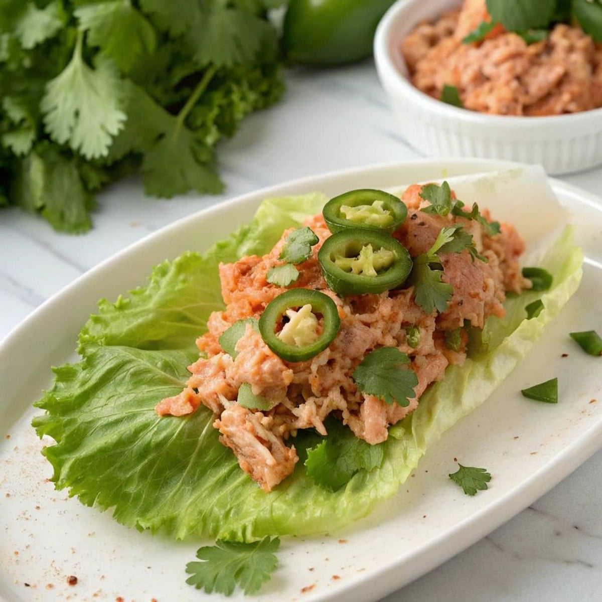 Jalapeño tuna pouch served on lettuce leaf with sliced jalapeños and cilantro