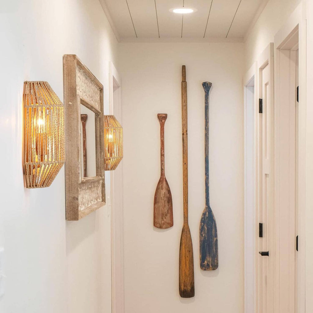 Two woven rattan wall sconces with amber light glowing from inside the shades