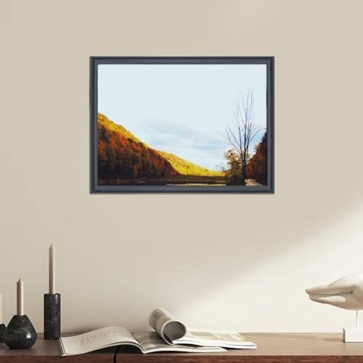 Black solid wood picture frame showing a landscape photo, wall display view.