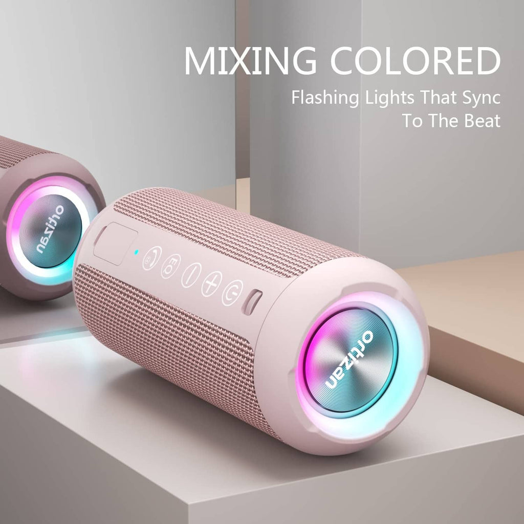 Pink portable Bluetooth speaker with multi-color LED ring on a shelf