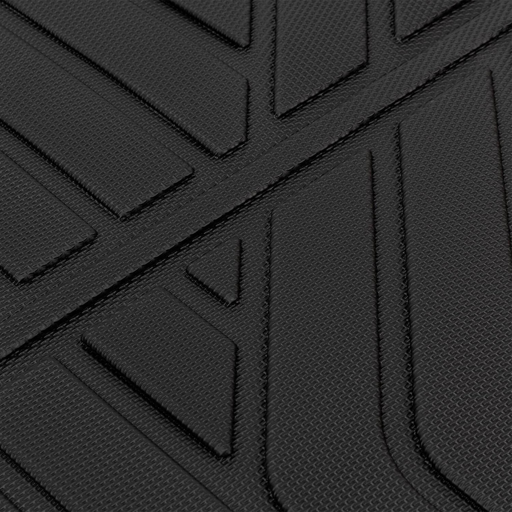 Black rubber floor mat surface with raised ridges and channels for traction, close-up