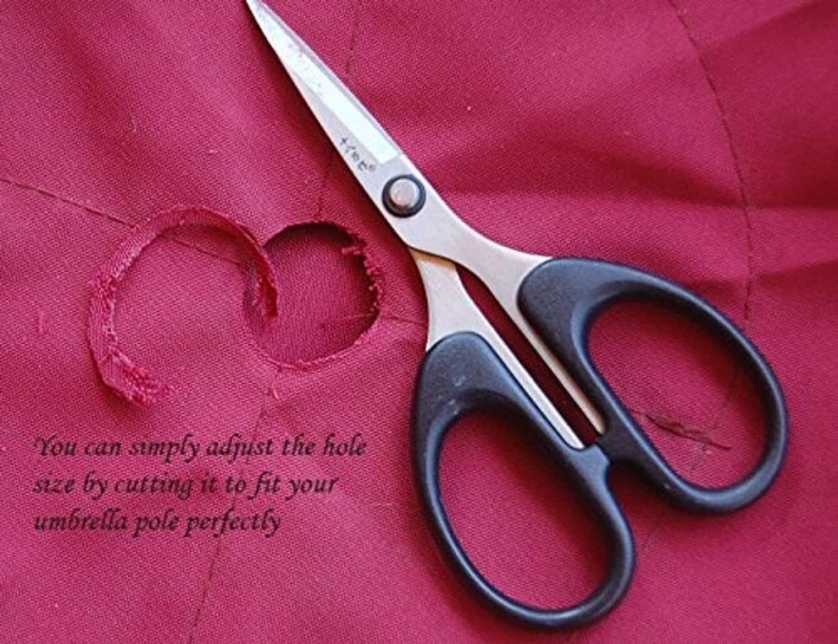 Red umbrella canopy fabric with cut hole and metal scissors