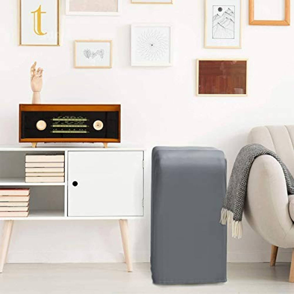 Gray portable air conditioner cover with simple front panel, placed beside furniture