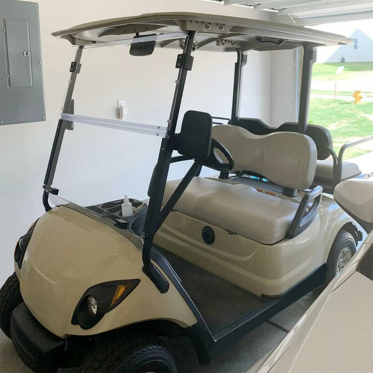 Installed clear windscreen on a beige golf cart, covering the front area with transparent panel