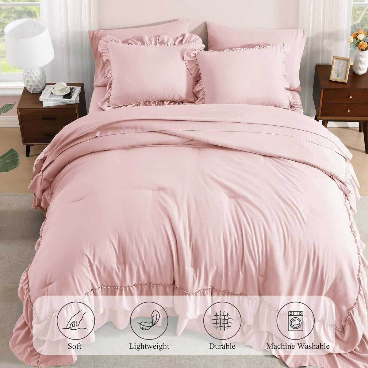 Blush pink queen comforter set with ruffled duvet skirt and decorative pillows on bed