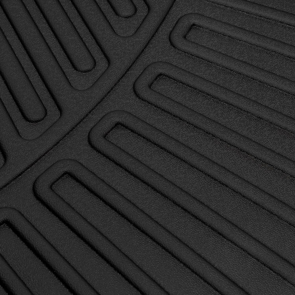 Close-up of black TPE floor mat with parallel molded grip channels and traction bumps