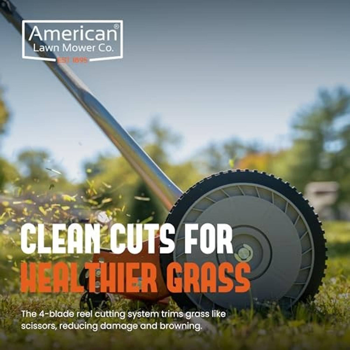 Close-up of orange reel lawn mower cutting deck with large front wheel